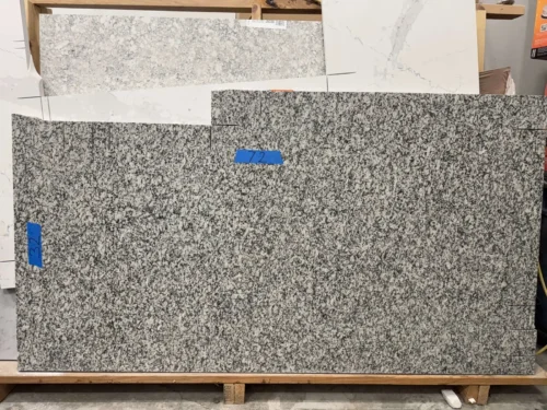 This granite slab features a classic speckled pattern with a mix of black, gray, and white tones, offering a durable and timeless look. Its strong composition makes it ideal for small vanity tops, shower seats, window sills, door sills, or similar applications.