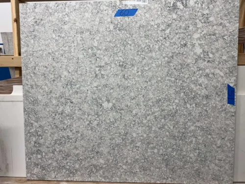 This quartz slab has a gray base with black and white speckled pattern, ideal for a timeless aesthetic. Its elegant design makes it perfect for small vanity tops, shower seats, window sills, door sills, or similar applications.